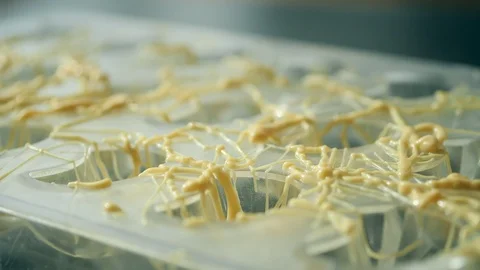 Making forms for sweets, decorating with white chocolate. Removing excess cho Stock Footage 127368566