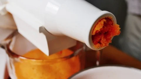 Making fresh carrot juice with a masticating juicer Stock Footage 79315937