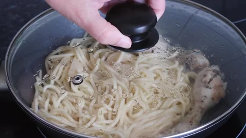 Making fried chicken legs and spaghetti. Cover food with glass lid. Stock-Footage 135411906