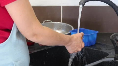 Making fried eggs with vegetables at home. A woman washes vegetables under the t Stock Footage 317542825