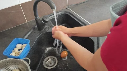 Making fried eggs with vegetables at home. A woman washes vegetables under the t Stock Footage 317544268