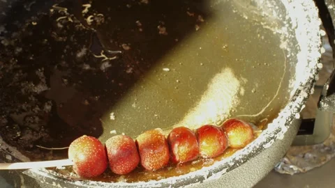 Making fruits in boiling caramel close-up. Chinese winter sweet dessert Tanghulu Stock Footage 264674920