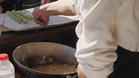 Making fruits in boiling caramel close-up. Chinese winter sweet dessert Tanghulu Stock Footage 265915016