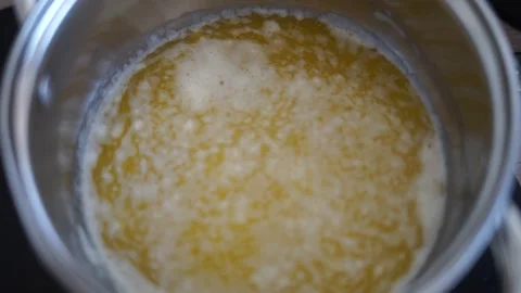 Making ghee butter boiling in pot healthy nutritious eco made at home yellow Stock Footage 287917407
