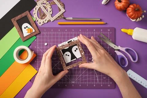 Making a ghost portrait craft. Hands glue the frame onto the picture Stock Photos