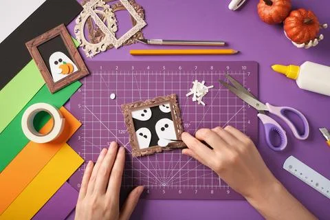 Making a ghost portrait craft. The hands glue the ghost's hand onto the frame Foto stock