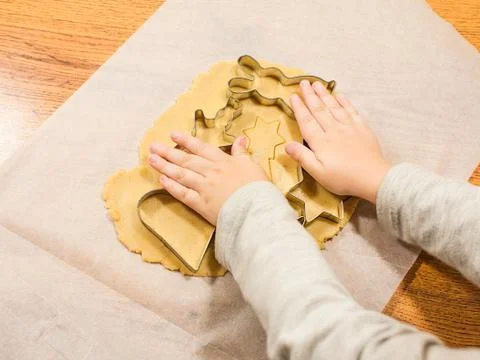 Making gingerbread with cookie cutters on baking paper Stock Photos