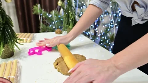 Making gingerbread dough with hands in front of a Christmas tree and garland Stock Footage 344820197