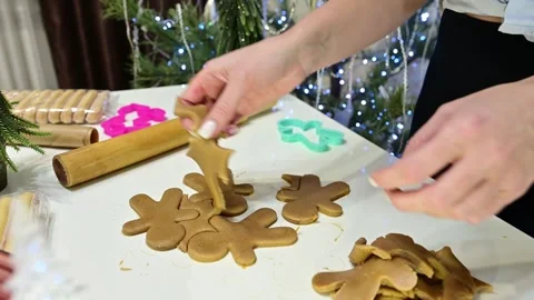 Making gingerbread shapes with hands near a Christmas tree and garland Stock Footage 345572847