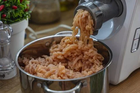 Making ground meat in a kitchen with a meat grinder Stock Photos
