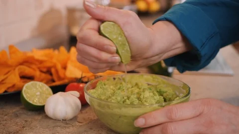 Making guacamole - hands squeezing lime on top Video stock 126224514