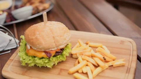 Making a Hamburger with Barbecued Beef Patty, onion, melted cheese, A hamburger Video stock 336579200