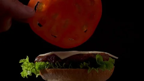 Making hamburger collected in parts. put a tomato Stock Footage 77064783