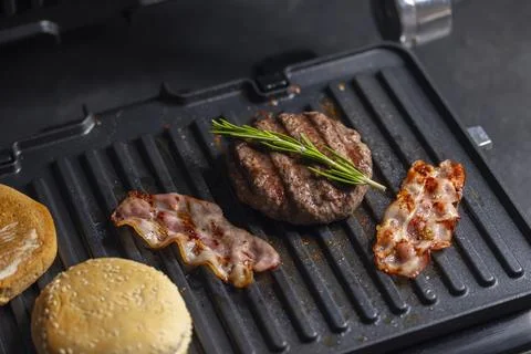 Making hamburger on the electric grill Stock Photos