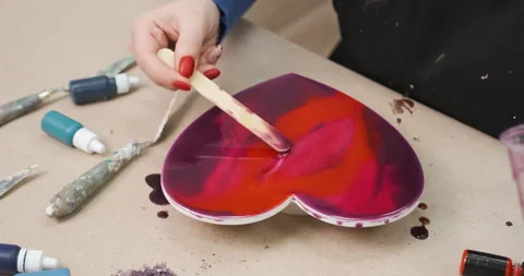 Making handmade gift for Saint Valentine's Day. Painting red heart with epoxy Stock Footage 168966492