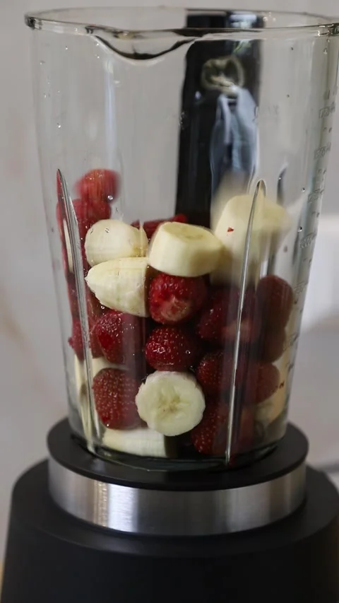 Making a healthy fruit smoothie (milkshake) with fresh strawberries Stock Footage 337835132