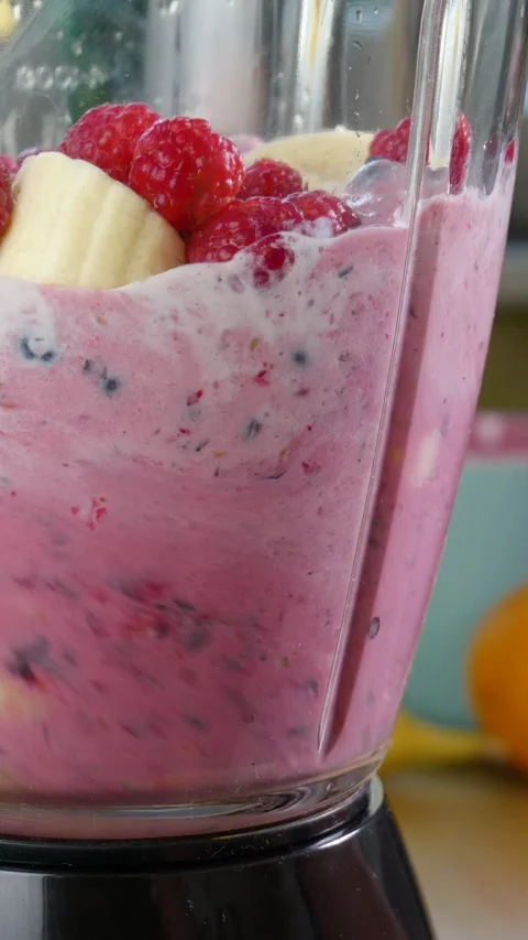 Making a Healthy Raw Vegan Raspberry Blueberry Banana Smoothie Stock Footage 257096961