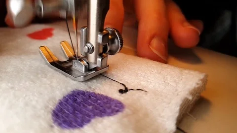 Making heart pattern with thread on a sewing machine with love. Woman is Stock Footage 110967303