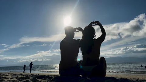 Making a heart in the sunset on the beach Stock Footage 228869304