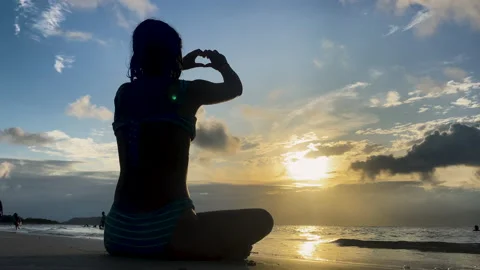 Making a heart in the sunset on the beach Stock Footage 228870524
