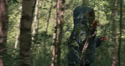 Making her way through the branches of trees in the forest, a woman is running Stock Footage 278789280