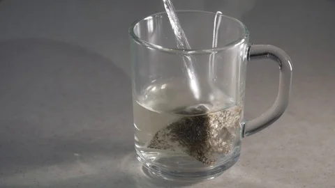 Making herbal tea with teabag in transparent mug Stock Footage 104494749