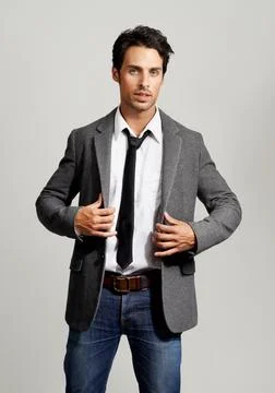Making himself presentable. Portrait of a handsome young man pulling his blazer Stock Photos