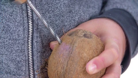 Making a hole into a coconut with a drill Stock Footage 83725967