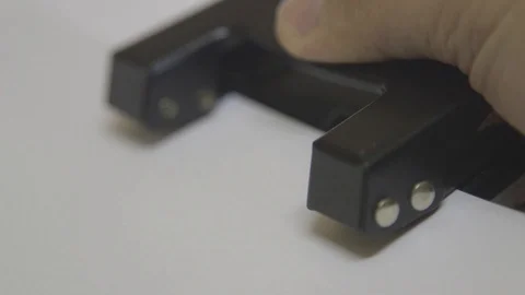 Making Hole in White Paper using paper puncher Stock Footage 123724944