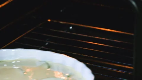 Making homemade apple pie. Placing baking sheet with raw pie on the rack in hot Stock Footage 105473674