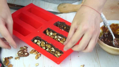 Making homemade chocolate bars with nuts and caramel in silicone mold Stock Footage 150673467