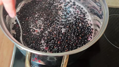 Making homemade jam from black currant berries in the kitchen Stock Footage 341619691