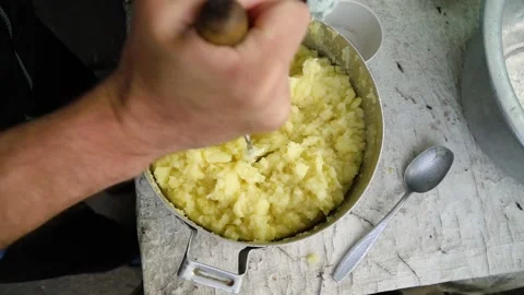 Making homemade mashed potatoes, mixing with your hands in a saucepan. Top view Stock Footage 194444337