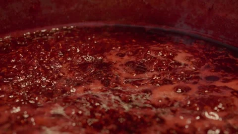 Making homemade raspberry jam in a stainless steel saucepan Stock Footage 320952786