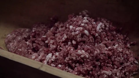 Making of hungarian pork sausage, milling raw meat into trough Stock Footage 70351353