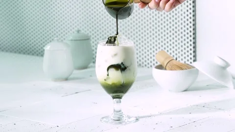 Making Iced Matcha Latte in Glass Cup 動画素材 334697988