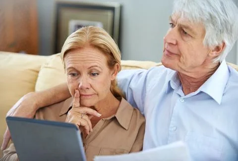 Making an informed decision. an elderly couple going over their paperwork with Fotos Stock