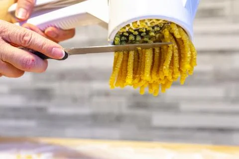 Making the italian fresh pasta `passatelli` close up with the special tool Stock Photos