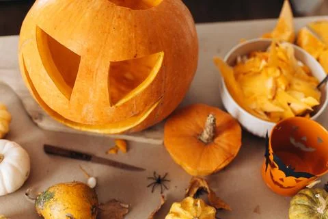 Making jack o lantern. Carving halloween pumpkin on table with spooky hallo.. Stock Photos