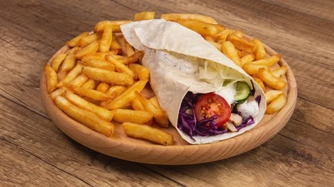 Making a kebab or gyros with a side of fried potatos Video stock 124614343