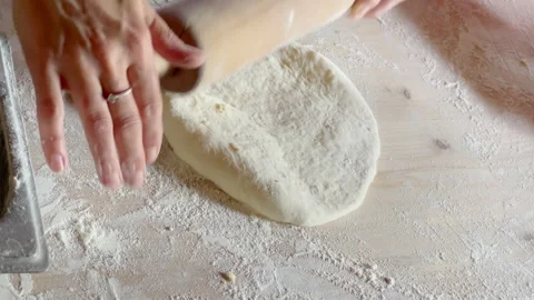 Making a khachapuri base using rolling pin on the flour covered home table. Home Stock-Footage 213683219