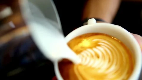 Making of latte art. Latte is a coffee drink made with espresso and steamed Vídeo Stock 334650012