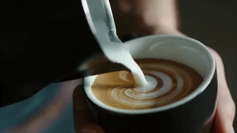 Making of latte art. Latte is a coffee drink made with espresso and steamed 動画素材 334650268