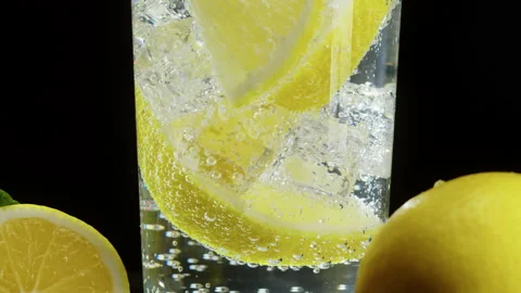 Making lemon cocktail on black background. Citrus fresh drink with ice. Healthy Stock Footage 168557569