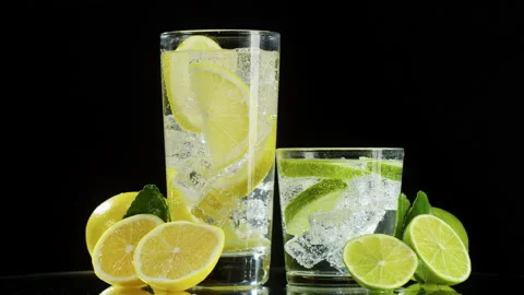 Making lime and lemon cocktail on black background. Citrus fresh drink with ice Stock Footage 168558371