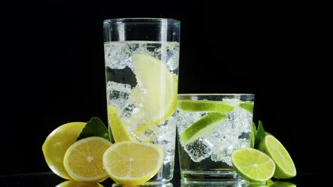 Making lime and lemon cocktail on black background. Citrus fresh drink with ice Stock Footage 169114831