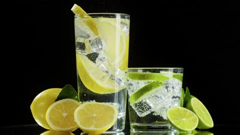 Making lime and lemon cocktail on black background. Citrus fresh drink with ice Stock Footage 169548896