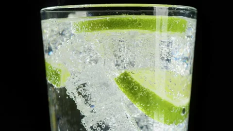 Making lime cocktail on black background. Citrus fresh drink with ice. Healthy Stock Footage 168558720