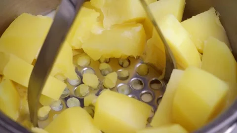 Making mashed potatoes with potato masher Stock Footage 305965047