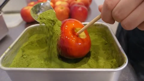 Making Matcha Candy Apple Dipping Glossy Red Apple in Green Tea Powder Stock Footage 345292673